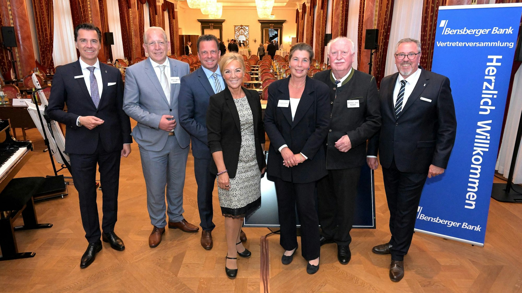 Sieben Menschen stehen vor einem Saal des Bensberger Schlosses.