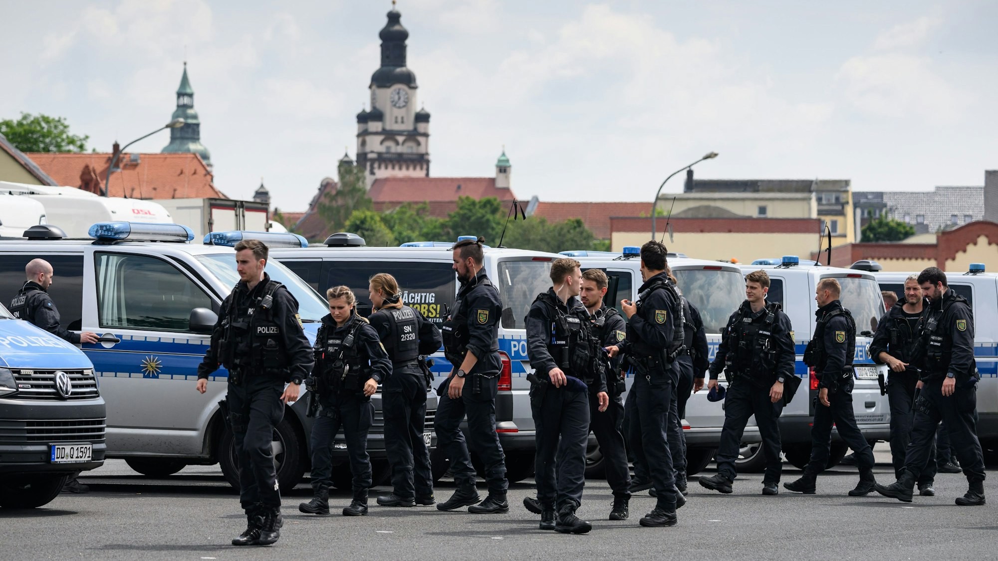 Döbeln: Polizisten versammeln sich auf einem Parkplatz.