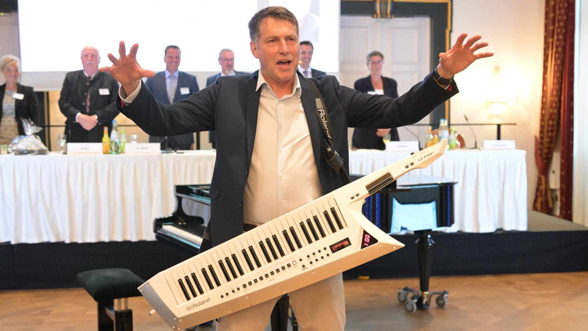 Ein Mann mit Umhängepiano macht Stimmung,