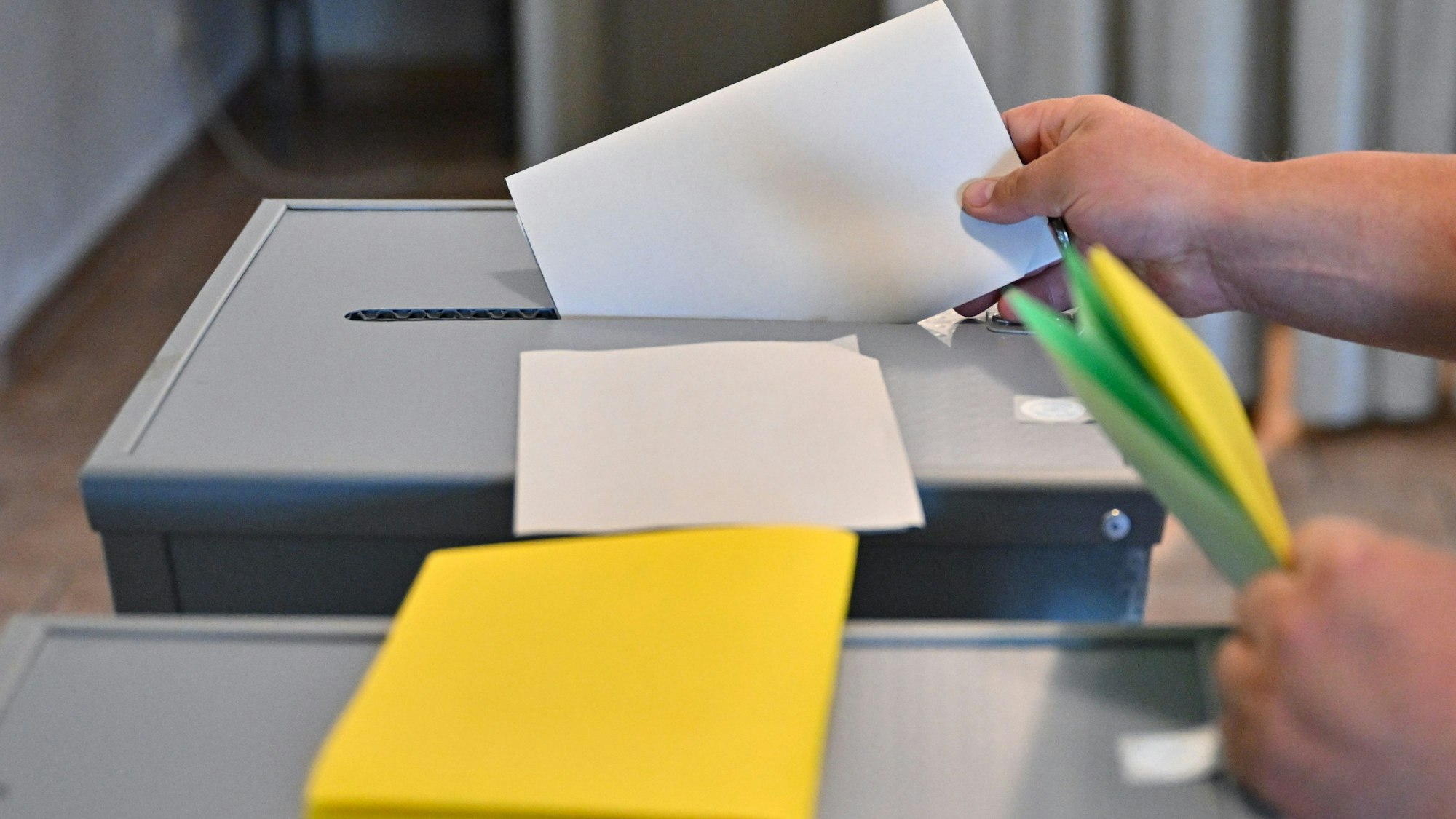 09.06.2024, Sachsen, Gablenz: Eine Person steckt seinen Wahlzettel zu Europawahl in eine Wahlurne. Die Europawahl begann am 6. Juni und in Deutschland wird am 9. Juni gewählt. In Sachsen sind Kommunalwahlen und zeitgleich die Europawahl. (zu dpa: «In Sachsen zeichnet sich ähnliche Wahlbeteiligung wie 2019 ab») Foto: Patrick Pleul/dpa +++ dpa-Bildfunk +++