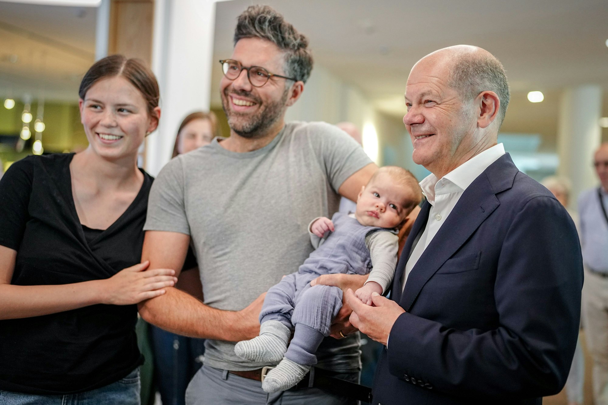 09.06.2024, Brandenburg, Potsdam: Bundeskanzler Olaf Scholz (r, SPD) steht nach seiner Stimmabgabe für die Europawahl in seinem Wahllokal mit Elisabeth und Valentin Jahn (l-r) mit ihrem Baby Benedikt für ein Foto zusammen. Foto: Kay Nietfeld/dpa-Pool/dpa +++ dpa-Bildfunk +++
