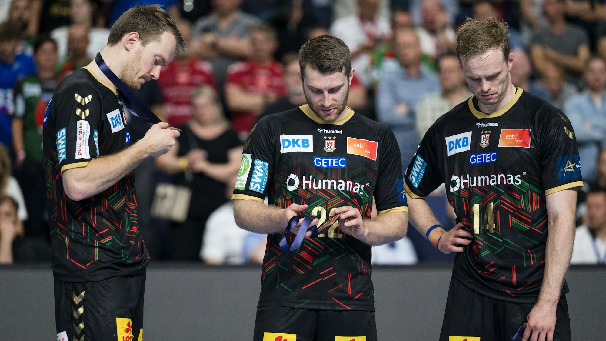 Magdeburgs Spieler Felix Claar (l-r), Lukas Mertens und Omar Ingi Magnusson stehen nach dem verlorenen Spiel um Platz drei bei der Siegerehrung zusammen.