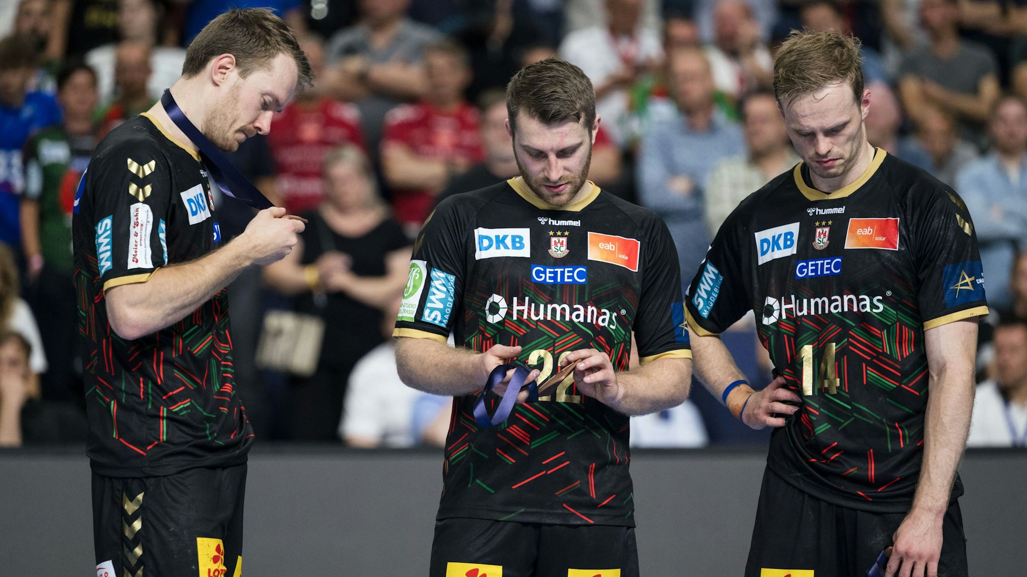 Magdeburgs Spieler Felix Claar (l-r), Lukas Mertens und Omar Ingi Magnusson stehen nach dem verlorenen Spiel um Platz drei bei der Siegerehrung zusammen.