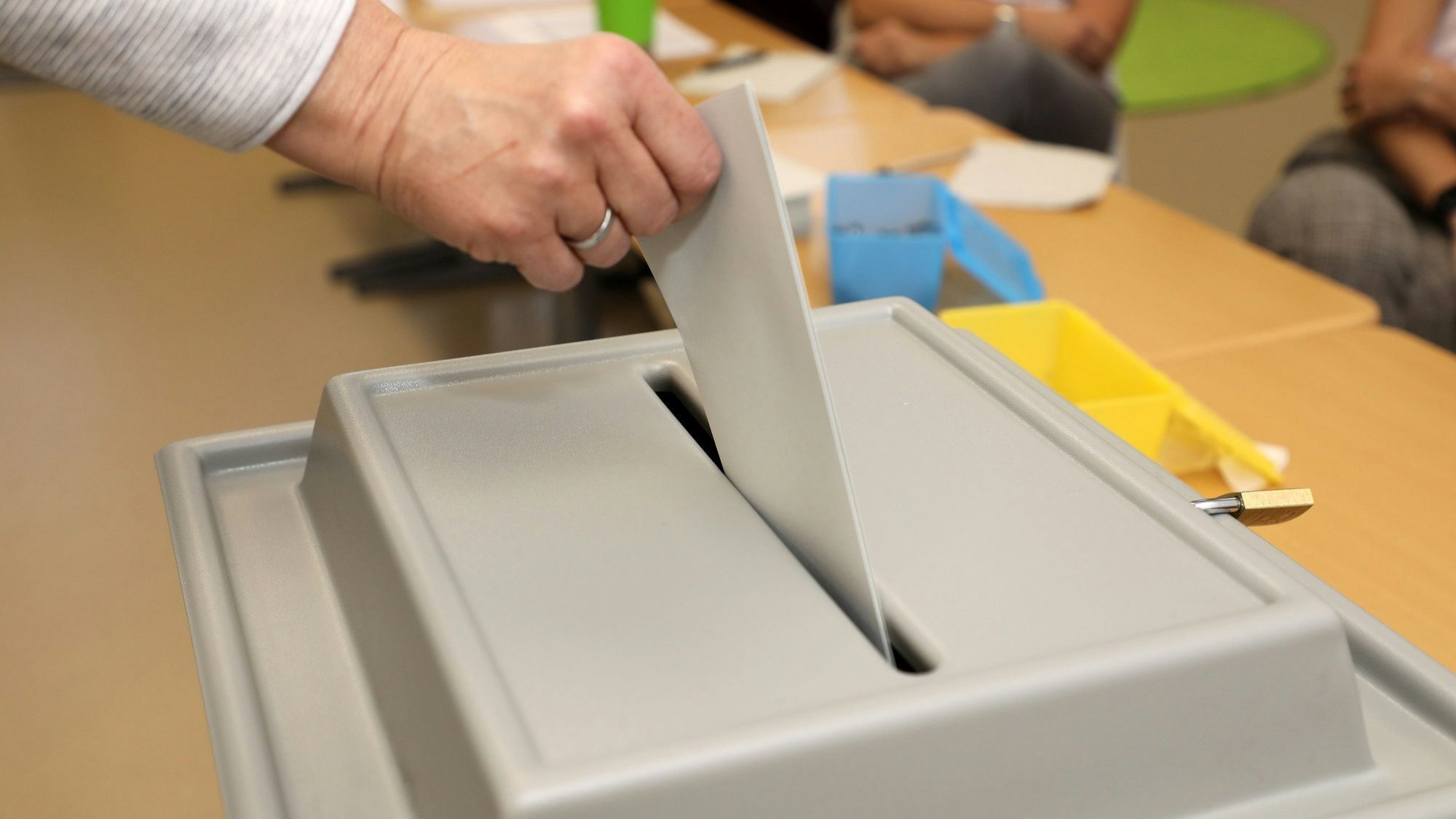 Das Foto zeigt, wie ein Stimmzettel in eine Wahlurne gelegt wird