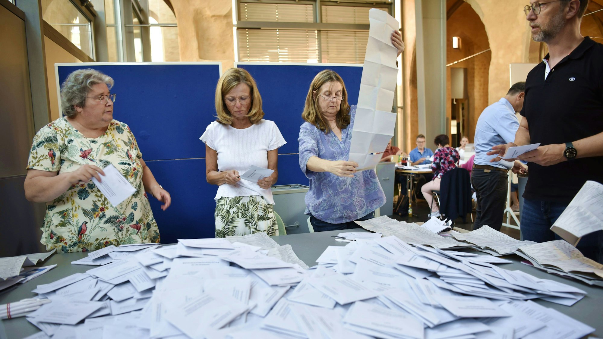 Drei Frauen und ein Mann öffnen die Briefwahlumschläge zur Europawahl in Zülpich.