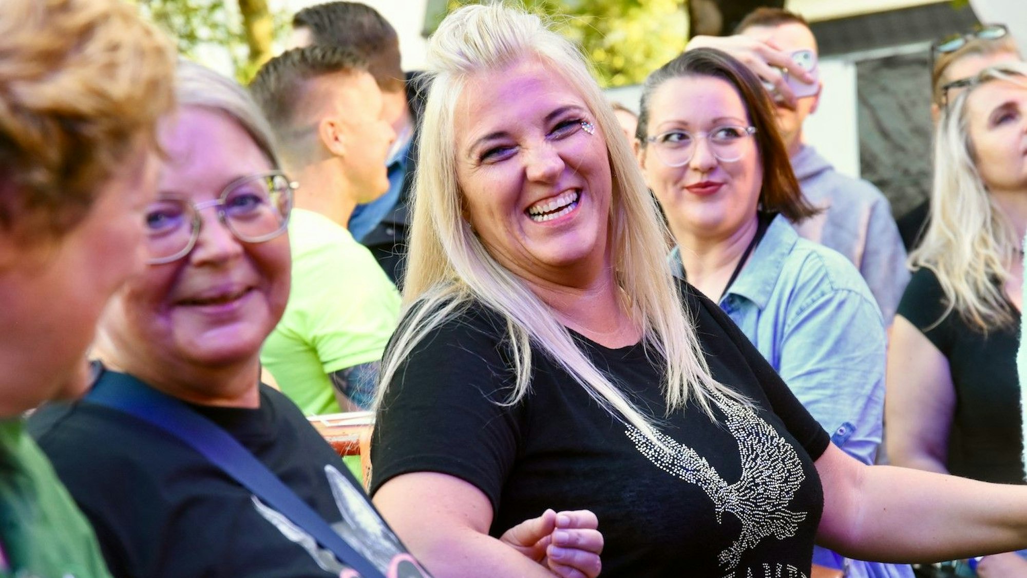 Lachende Frauen schunkeln.