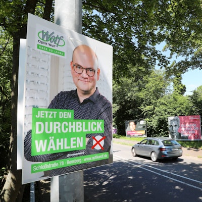 Neben Plakaten von Parteien zur Europawahl hängt ein der Wahlwerbung nachempfundenes Plakat eines Optikers, der für „Jetzt Durchblick wählen“ wirbt.