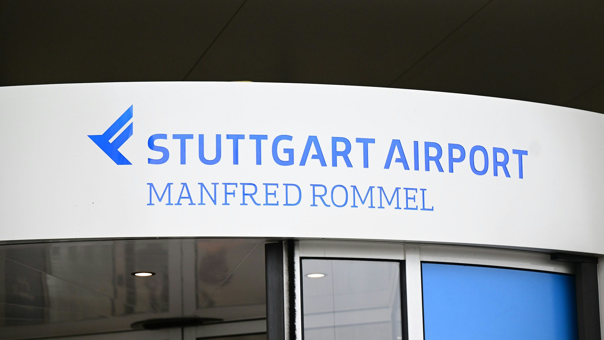 ARCHIV - 27.07.2023, Baden-Württemberg, Stuttgart: Das Logo des Manfred Rommel Flughafens in Stuttgart ist an einer Eingangstür angebracht. (zu dpa: «Maschine am Stuttgarter Flughafen evakuiert - vier leichtverletzte Mitarbeiter») Foto: Bernd Weißbrod/dpa +++ dpa-Bildfunk +++