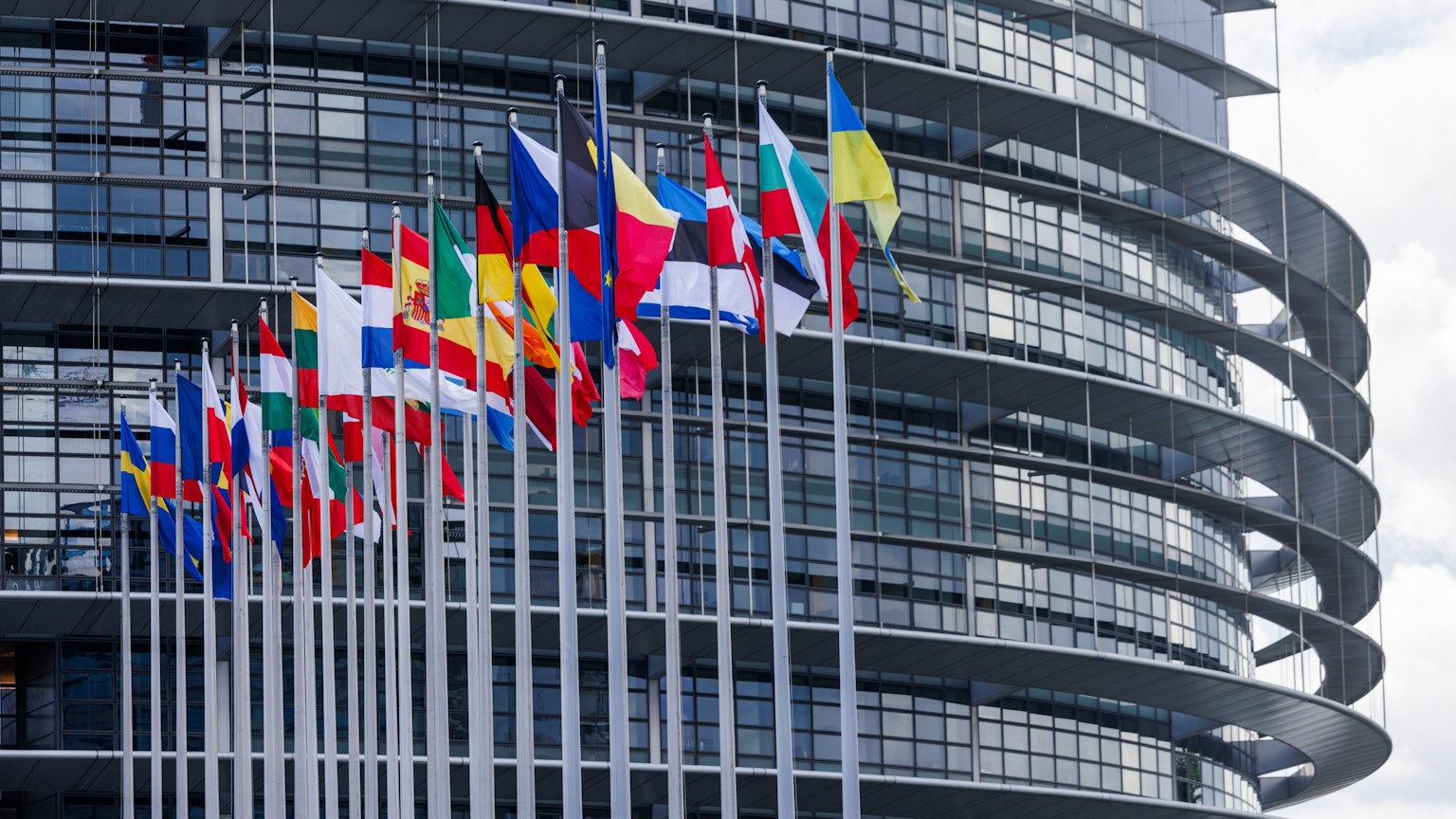 Die Flaggen der Europäischen Union, ihrer Mitgliedsstaaten sowie der Ukraine wehen vor dem Gebäude des Europäischen Parlaments.