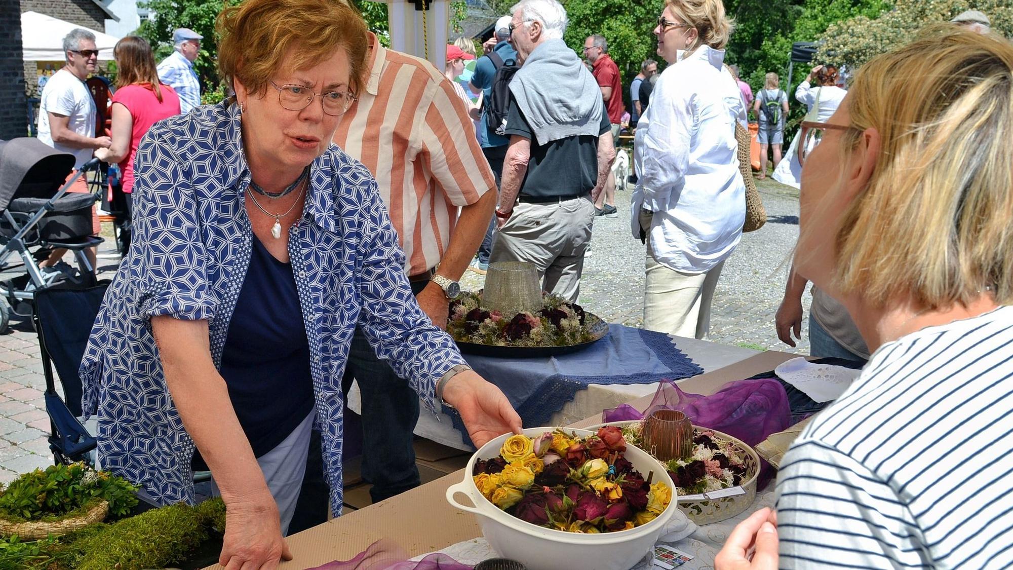 Pauline Hilger (l.) präsentiert ihre selbstgesteckten Blumenkränze.
