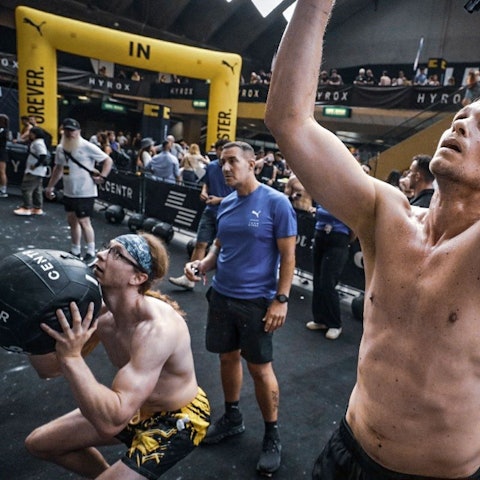 Muskulöse Männer mit freiem Oberkörper werfen einen Medizinball.