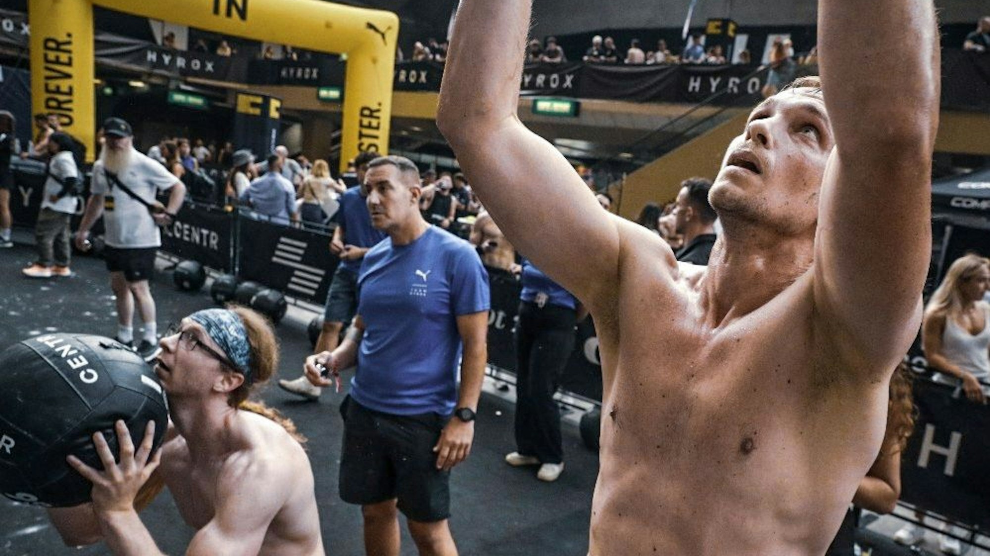 Muskulöse Männer mit freiem Oberkörper werfen einen Medizinball.