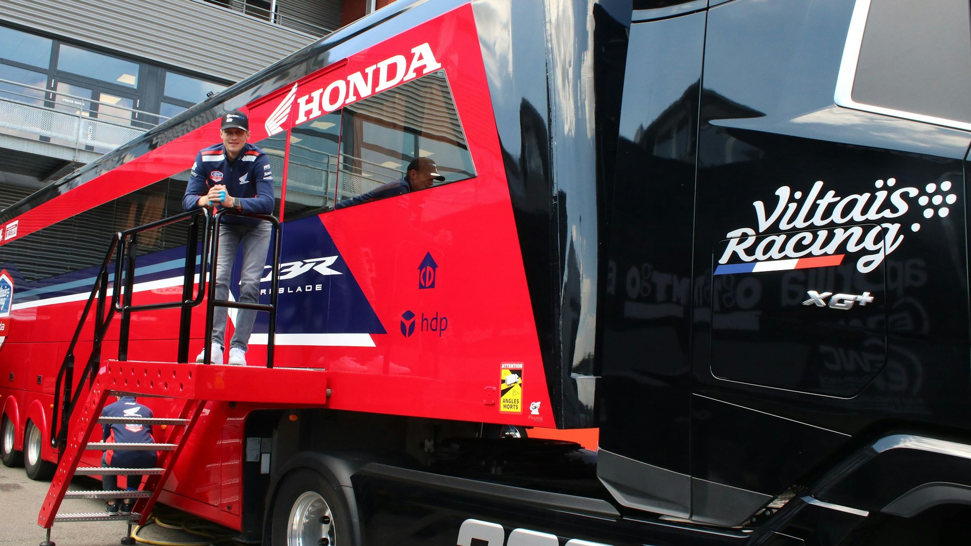 Florian Alt steht auf der Treppe des Team-Lkw und blickt herunter.