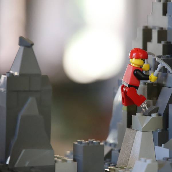 Eine Klemmbaustein-Figur steigt durch eine Fantasielandschaft.
