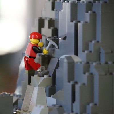 Eine Klemmbaustein-Figur steigt durch eine Fantasielandschaft.