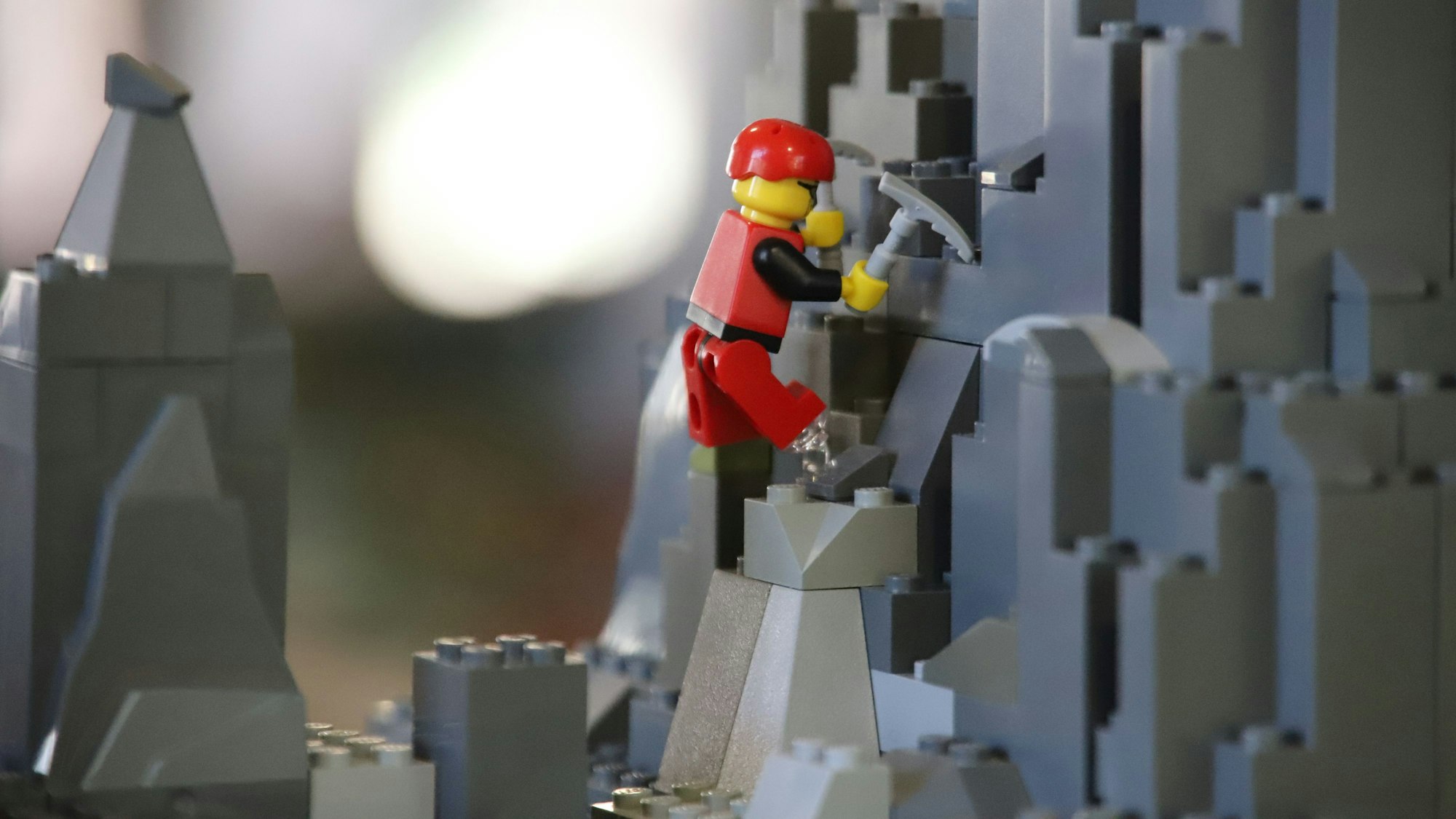 Eine Klemmbaustein-Figur steigt durch eine Fantasielandschaft.