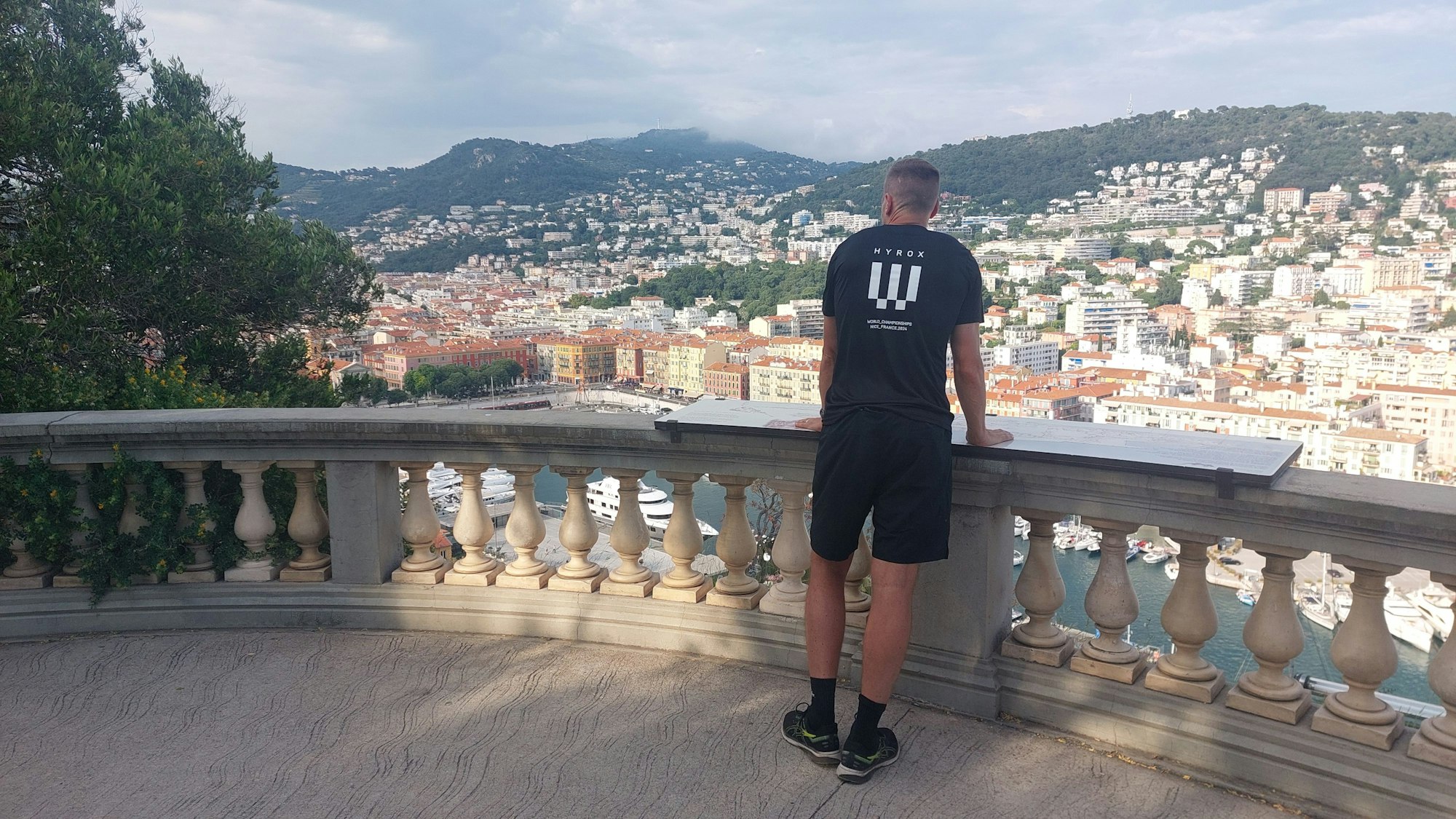 Roman Hopp steht an einer Balustrade und schaut auf Nizza.