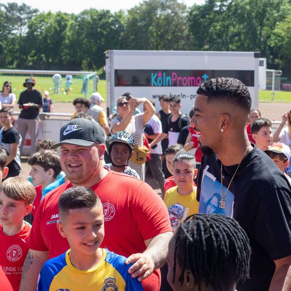 Fußball-Nationalspieler Benjamin Henrichs wird bei seiner Ankunft auf dem Sommerfest der Sportvereinigung Porz von jungen Kickern umringt.