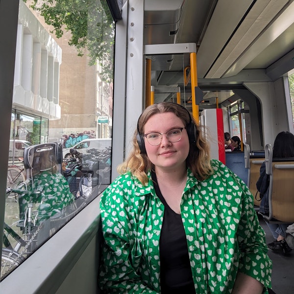 Eine junge Frau sitzt in einer Bahn.