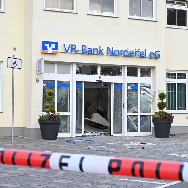 In Dahlem haben Unbekannte versucht, den Geldautomat der VR-Bank zu sprengen. Vor dem Gebäude mit dem blauen Schriftzug der Bank liegen Splitter, ein rot-weißes Band mit der Aufschrift Polizei sperrt den Tatort ab.
