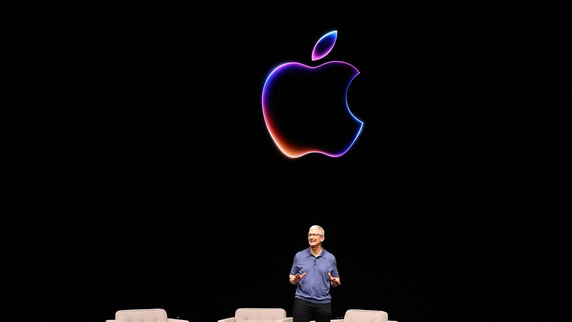 Man sieht Tim Cook, den CEO von Apple, wie auf einem Podium der Apple-Entwicklerkonferenz auf dem Apple Campus einen Vortrag hält.