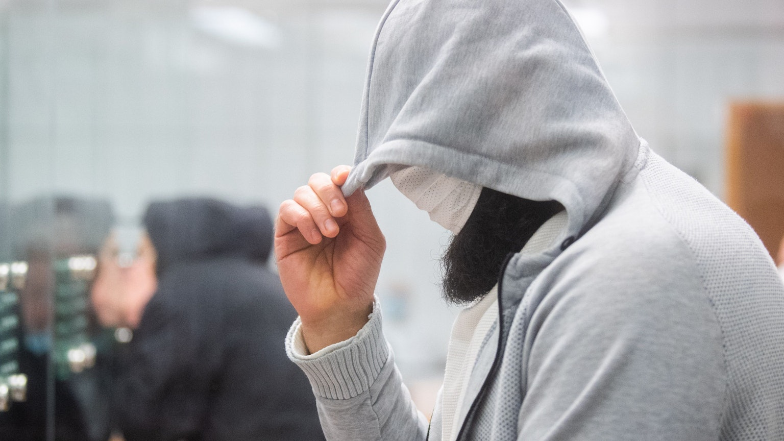 Celle: Abu Walaa, mutmaßlicher Anführer der Terrormiliz Islamischer Staat (IS) in Deutschland, steht im Oberlandesgericht hinter einer Glasscheibe.