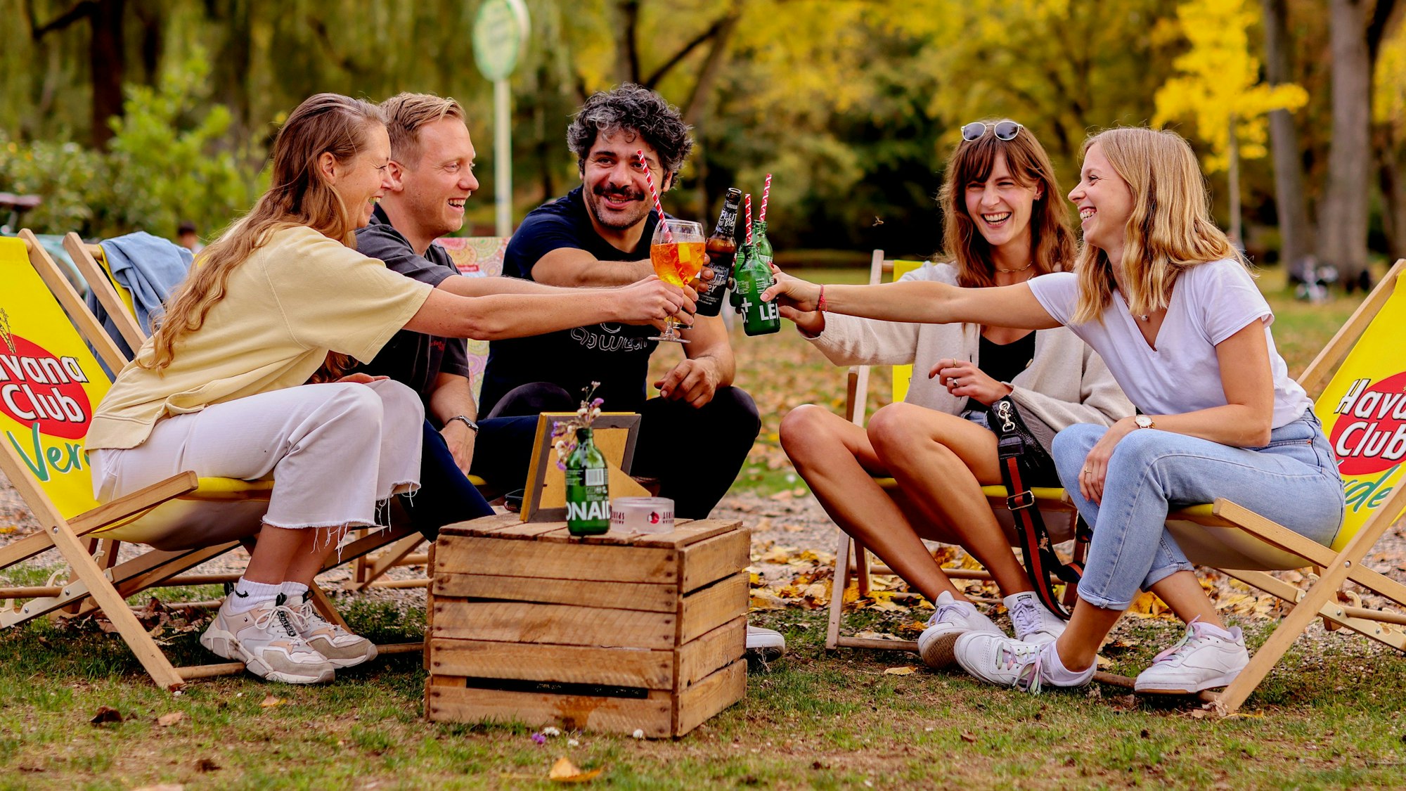 Junge Leute sitzen bei sonnigem und warmen Herbstwetter im Biergarten am Aachener Weiher in Köln.
