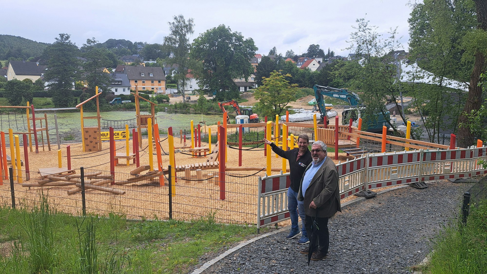 Das Foto zeigt den neuen Spielplatz mit Bürgermeister Stefan Meisenberg (r.) und Tobias Schmitz.