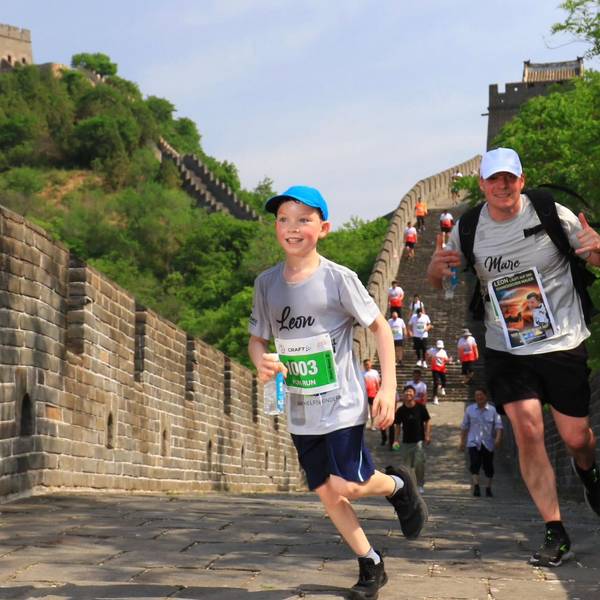 Leon und Vater Marc Marth tragen Kappen und laufen die Stufen der Chinesischen Mauer herunter.