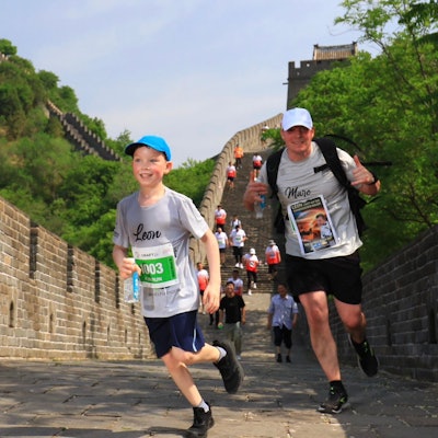 Leon und Vater Marc Marth tragen Kappen und laufen die Stufen der Chinesischen Mauer herunter.