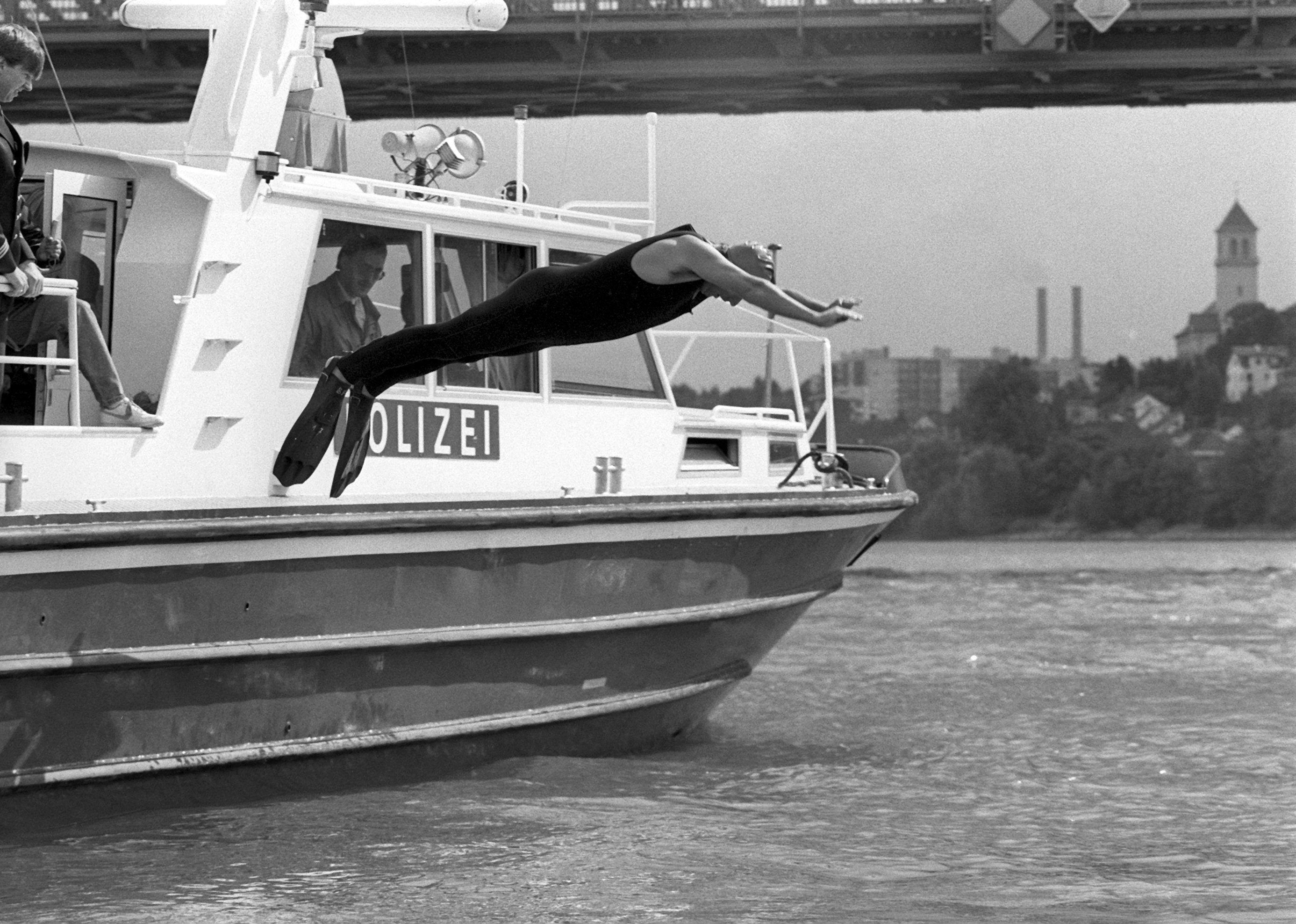 ARCHIV - 13.09.1988, Hessen, Mainz: Angetan mit einer Badekappe, einem Schutzanzug und Schwimmflossen, springt Klaus Töpfer (CDU), damaliger Bundesumweltminister, von Bord eines Polizeibootes in den Rhein. Der damalige Bundesumweltminister wollte mit seinem spektakulären Sprung beweisen, dass nach einer Reihe von Chemikalieneinleitungen die Flüsse wieder regenerierten. (zu dpa: «Ex-Umweltminister Klaus Töpfer gestorben») Foto: Roland Witschel/dpa +++ dpa-Bildfunk +++