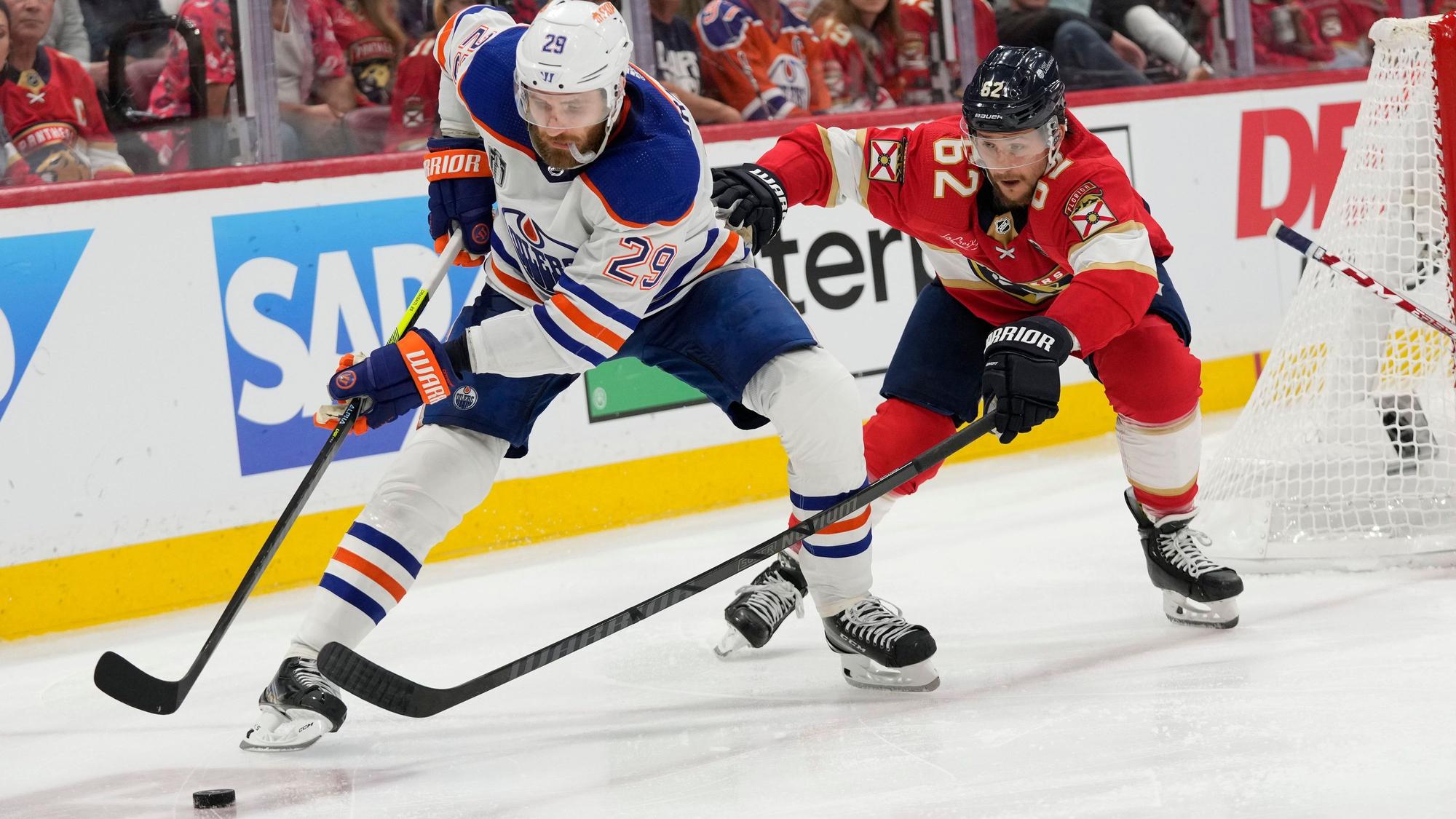 Leon Draisaitl (29), Center der Edmonton Oilers, und Brandon Montour (62), Verteidiger der Florida Panthers, jagen während des dritten Drittels von Spiel 2 der Stanley-Cup-Finals in der Eishockey-Liga NHL dem Puck nach.