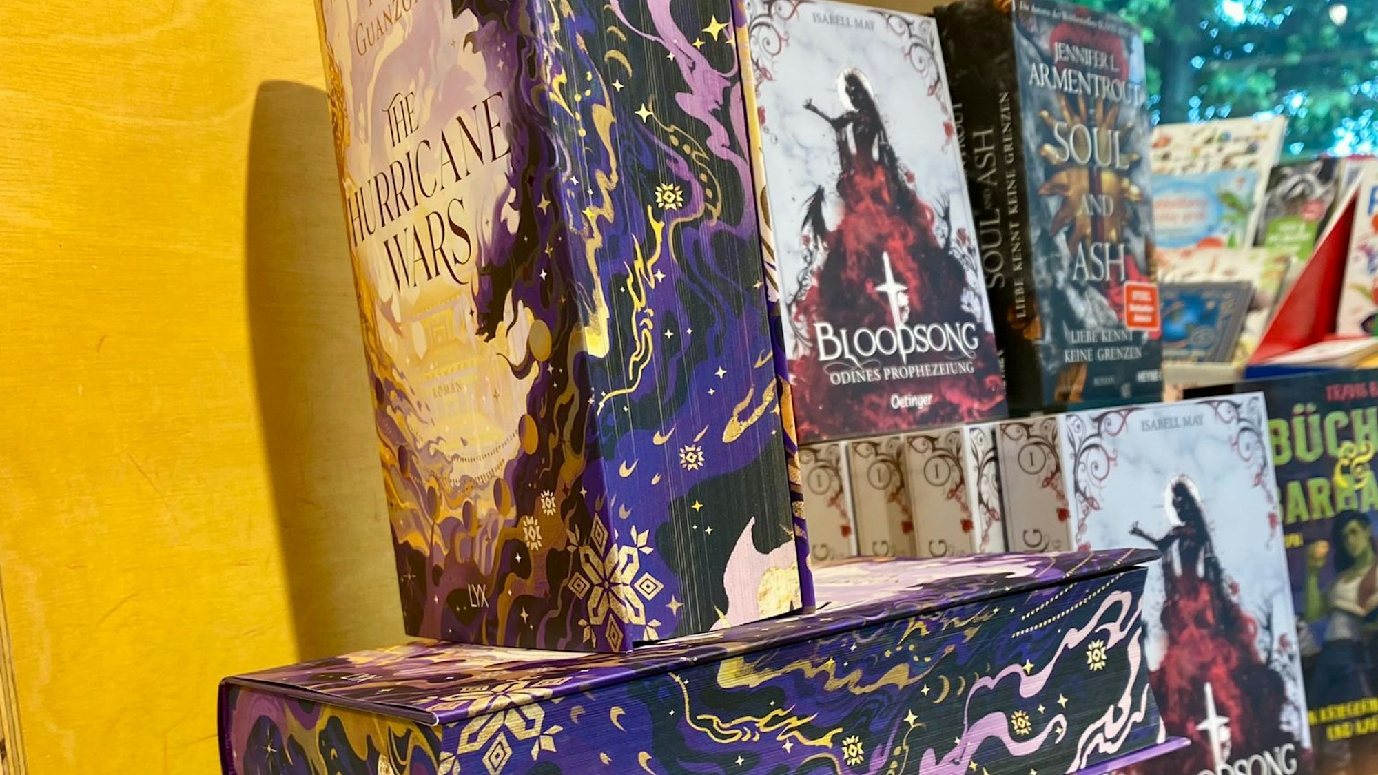 Vier Bücher mit farbigem Buchschnitt sind übereinander gestapelt.