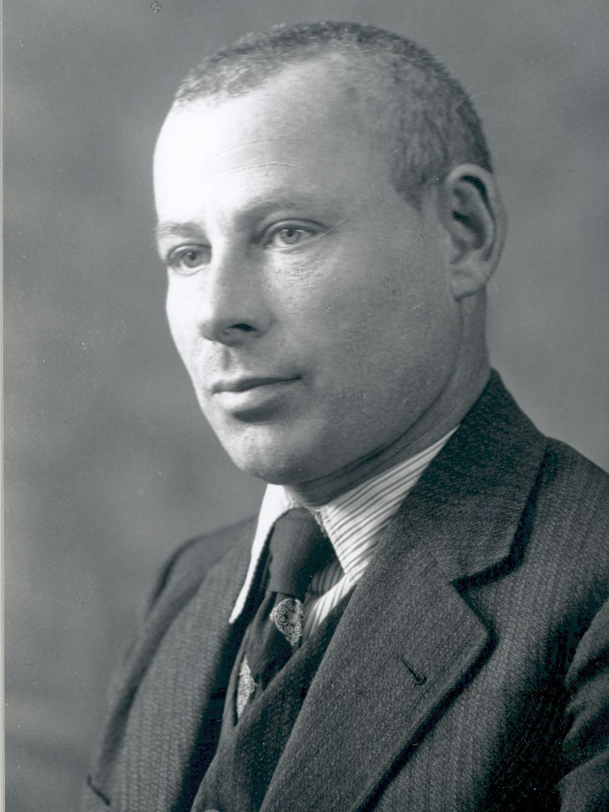 Ein schwarz-weißes Foto eines Mannes mit Anzug.