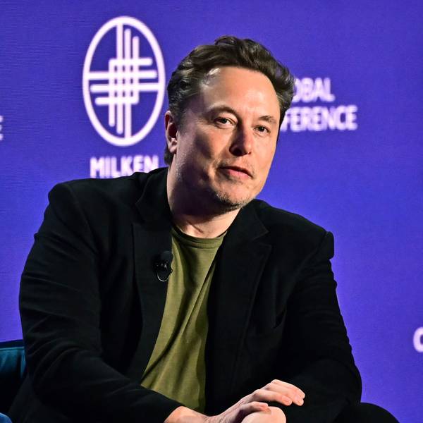 Tesla CEO Elon Musk spricht bei einer Konferenz auf einer Bühne.