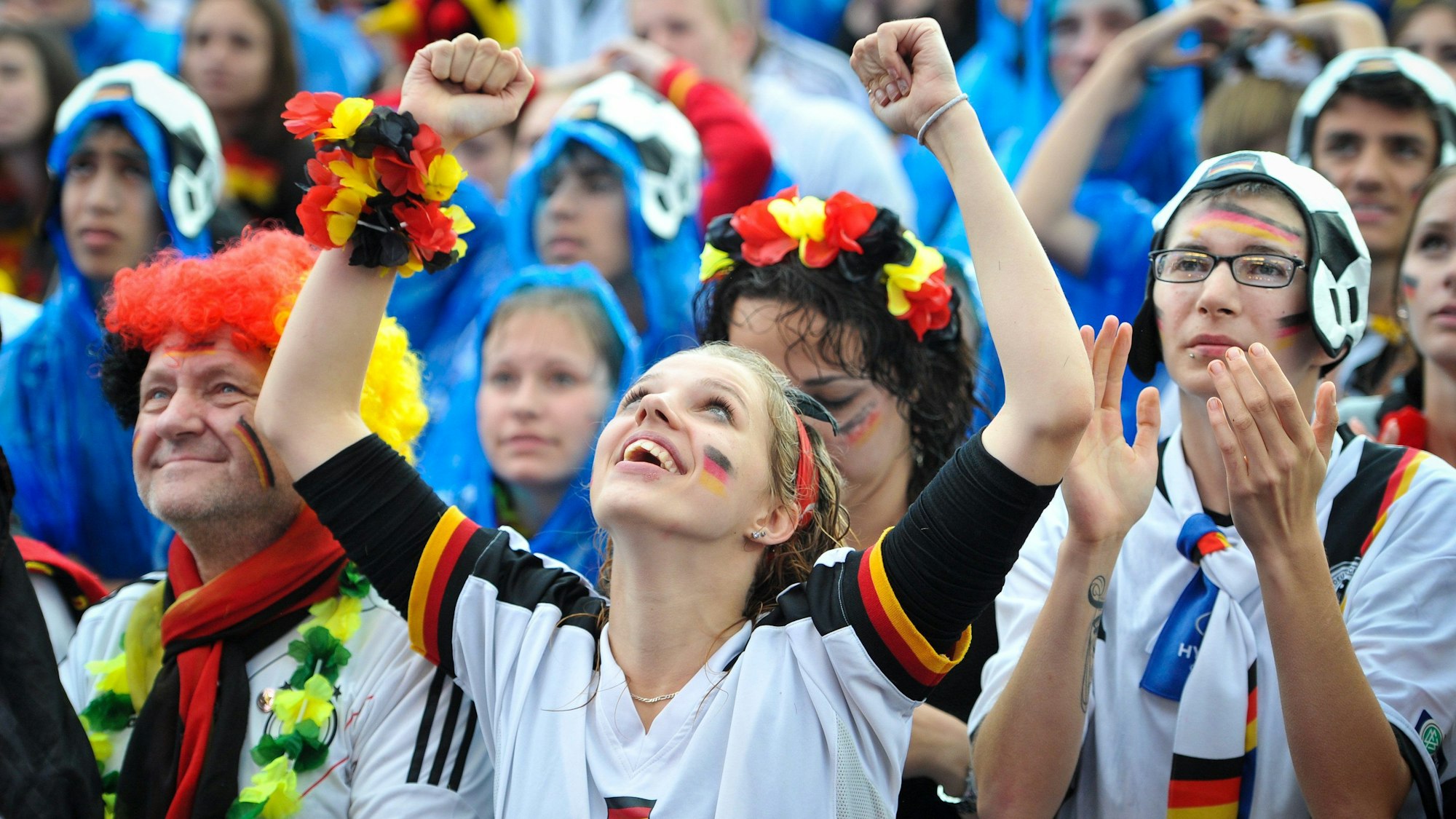 Besucher und Besucherinnen jubeln 2014 beim Public Viewing des WM-Fußballspiels Deutschland gegen USA.