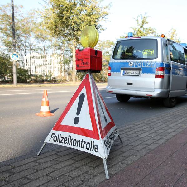 Ein dreieckiges Warnschild weist am Straßenrand auf eine Polizeikontrolle hin
