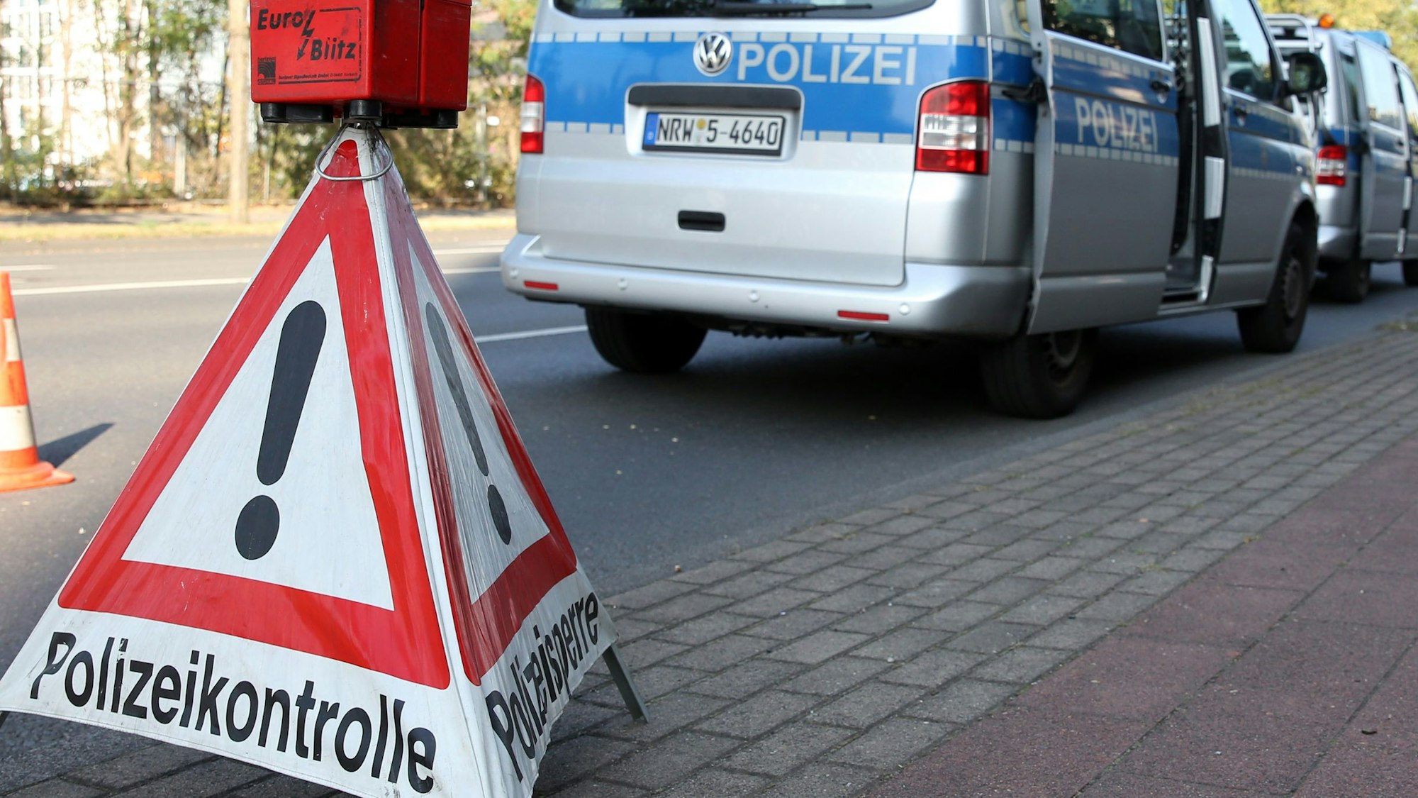 Ein dreieckiges Warnschild weist am Straßenrand auf eine Polizeikontrolle hin