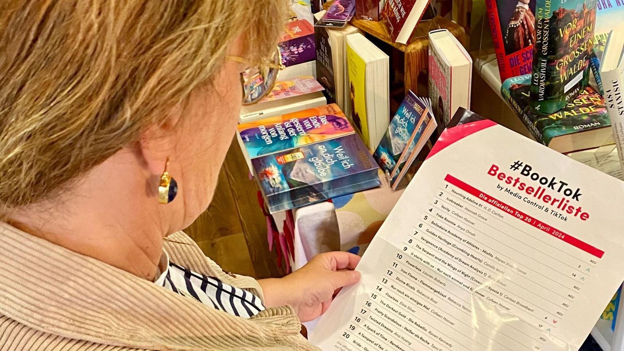 Renate Elsen hält ein Plakat in der Hand. Die Aufschrift: „BookTok Bestsellerliste“