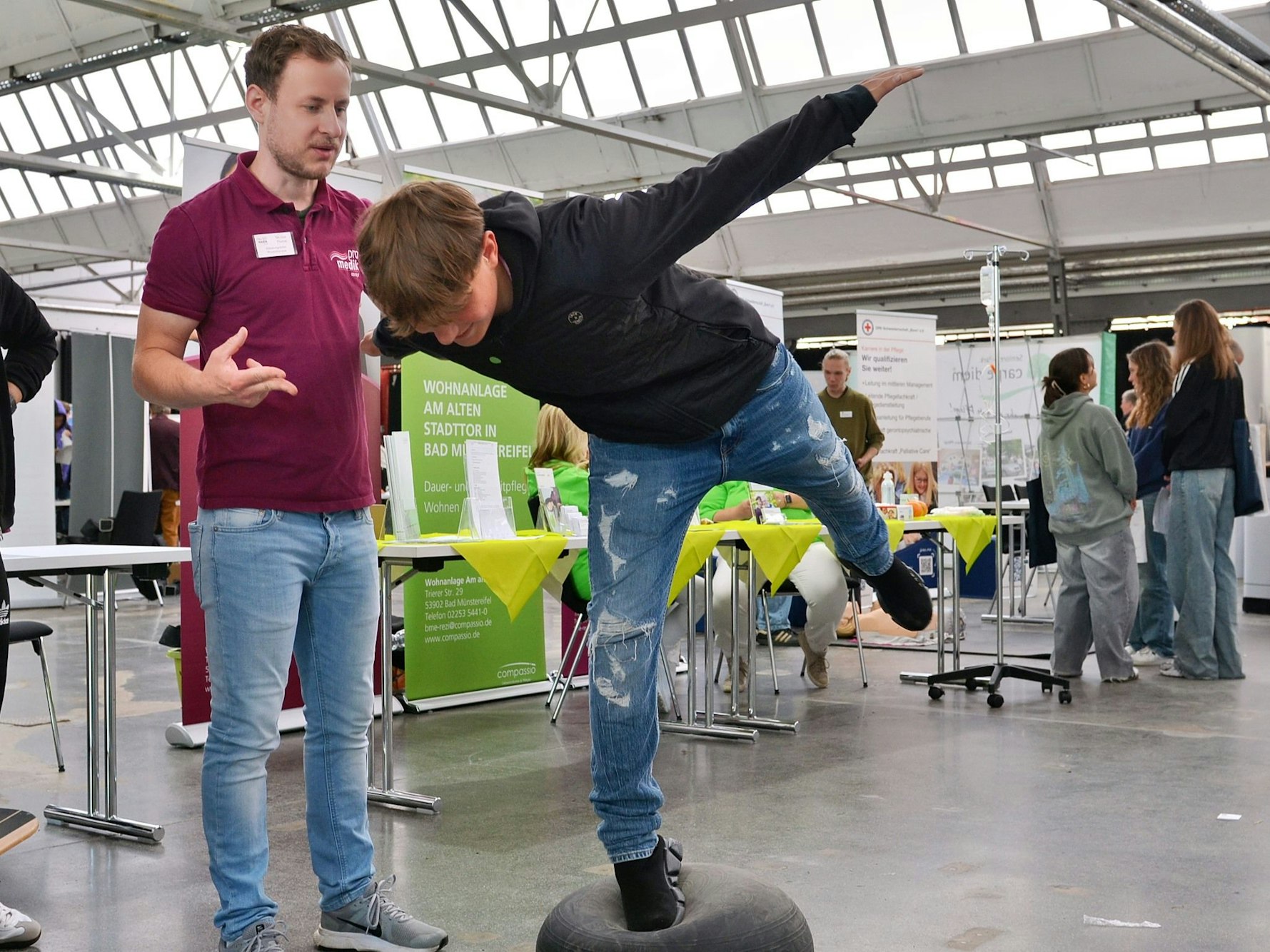 Ein Jugendlicher balanciert auf einem Bein auf einem Gummiball und beugt sich nach vorne.
