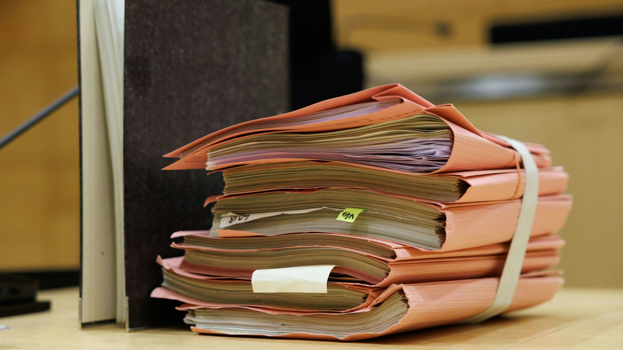 Prozessakten liegen in einem Gerichtssaal.