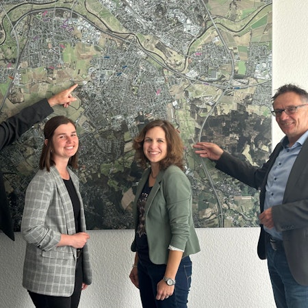 50 Jahre Wirtschaftsfördergesellschaft Sankt Augustin, von links: Geschäftsführer Edgar Bastian, Meike Karrenbauer, Anja Zimmermannund Geschäftsführer Rainer Gleß vor einem Luftbild des