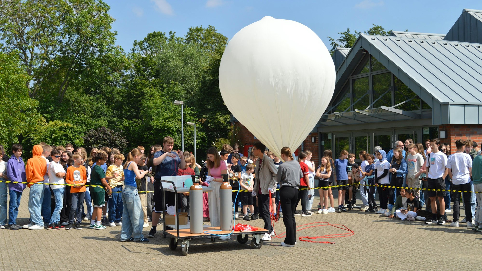Schülerinnen und Schüler lassen einen großen Wetterballon steigen.