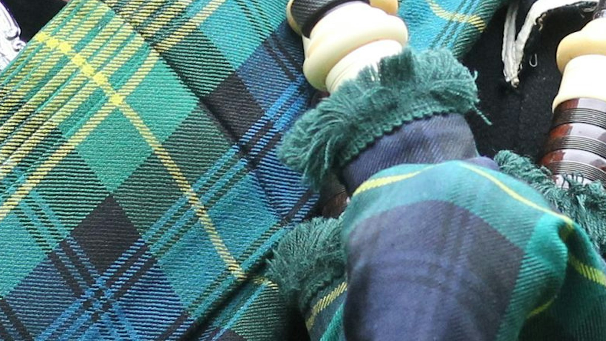 Nahaufnahme des karierten Tartanmusters mit den Farben Grün, Blau und Gelb.