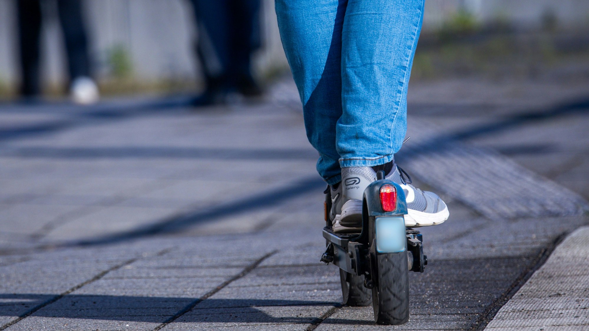 Ein Reisender fährt mit einem E-Scooter.