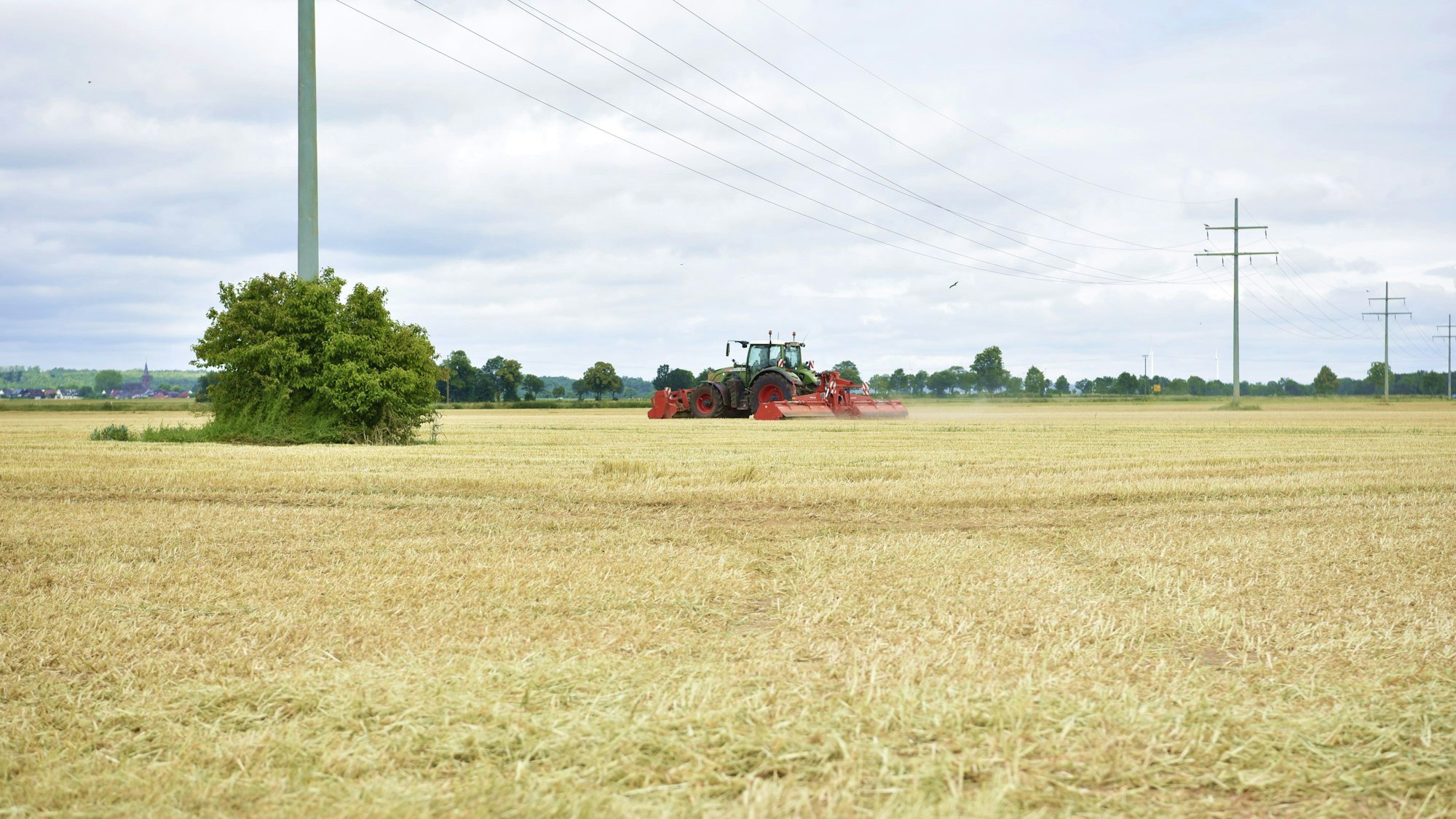 Ein Traktor fährt über ein Stoppelfeld in Floren.