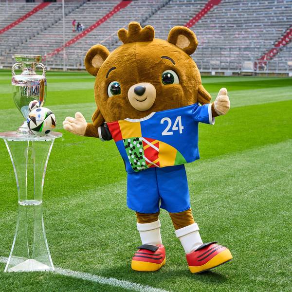Albärt und der Pokal stehen auf dem Stadionrasen.