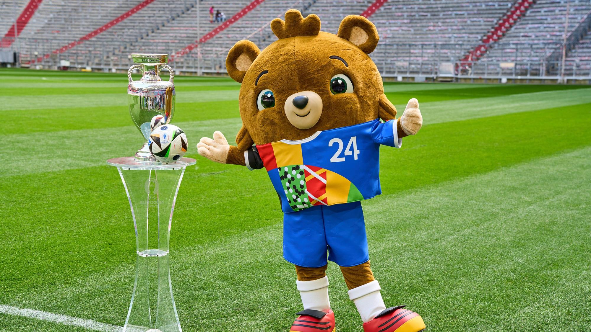 Albärt und der Pokal stehen auf dem Stadionrasen.