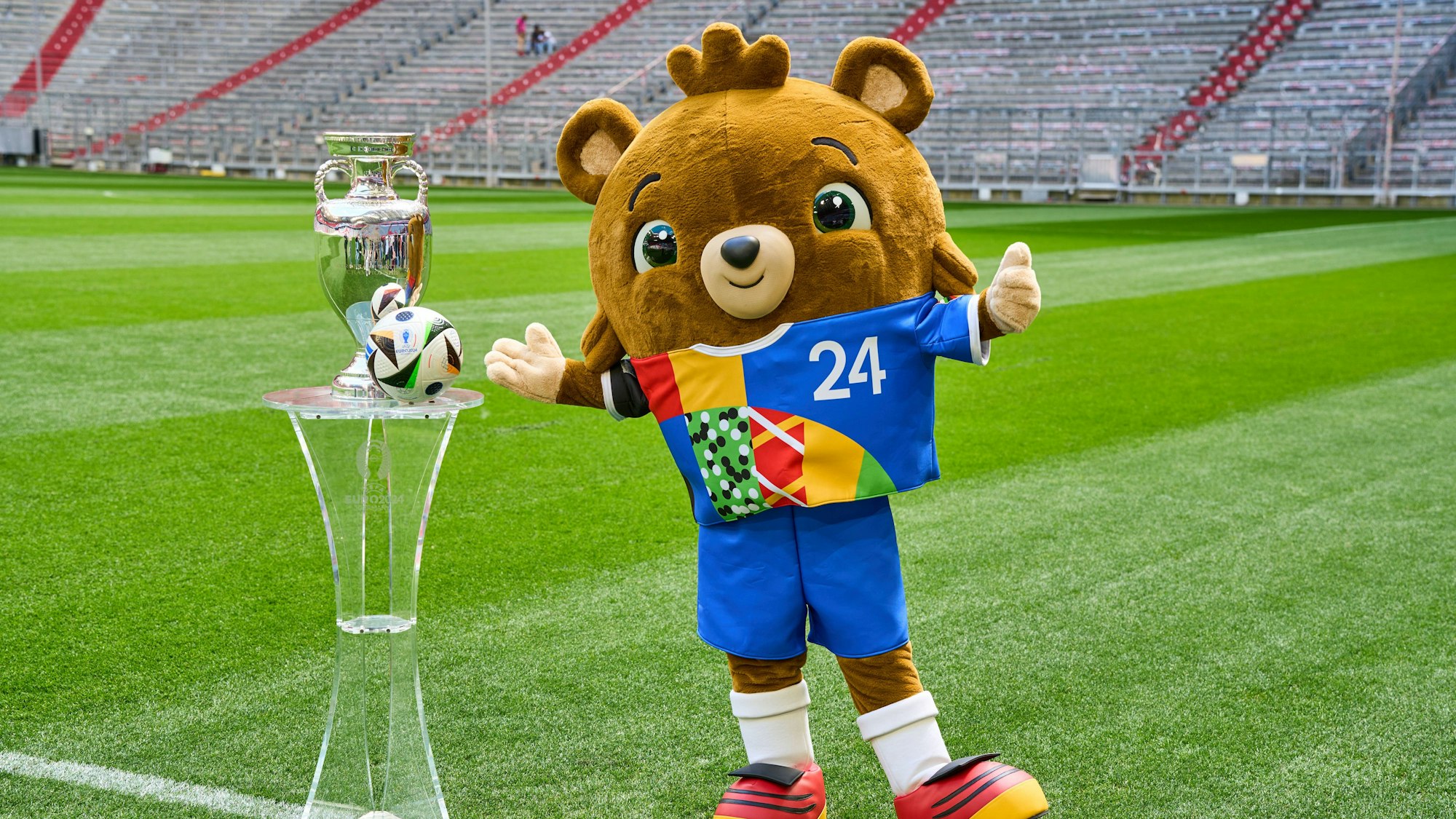 Albärt und der Pokal stehen auf dem Stadionrasen.