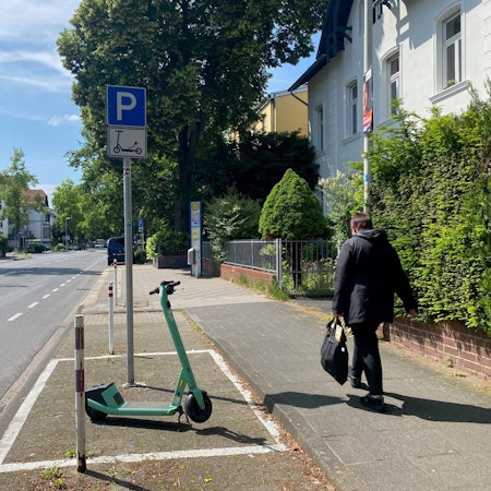 Zu sehen ist eine mit Schild und Markierung gekennzeichnete Abstellzone an einer Straße.